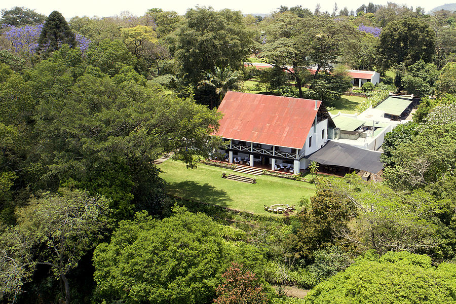View of the historic Ngare Sero Mountain Lodge main house surrounded by lush gardens