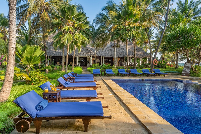 The serene main swimming pool area at The Palms Zanzibar, surrounded by palm trees