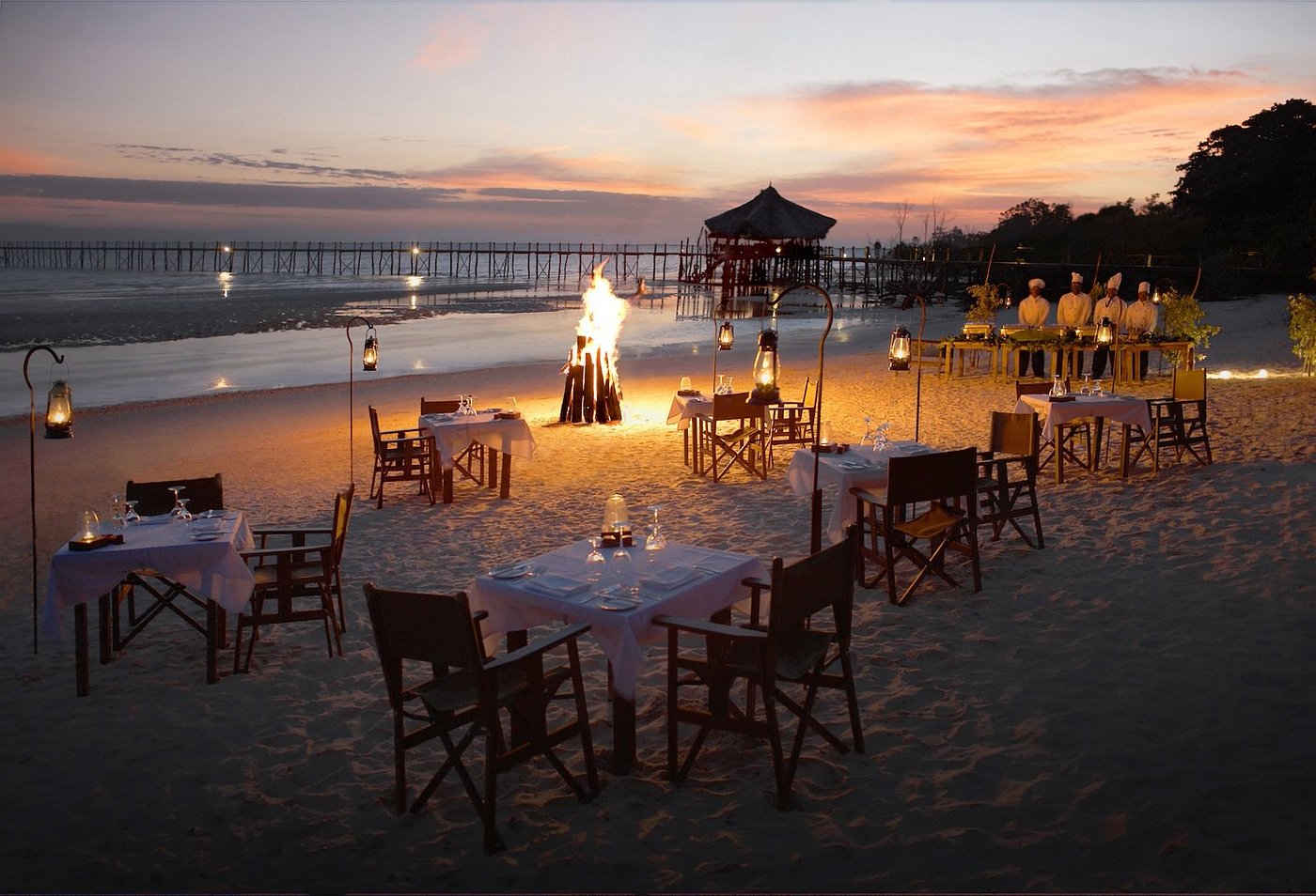 Couple relaxing by the infinity pool overlooking the ocean at Fundu Lagoon