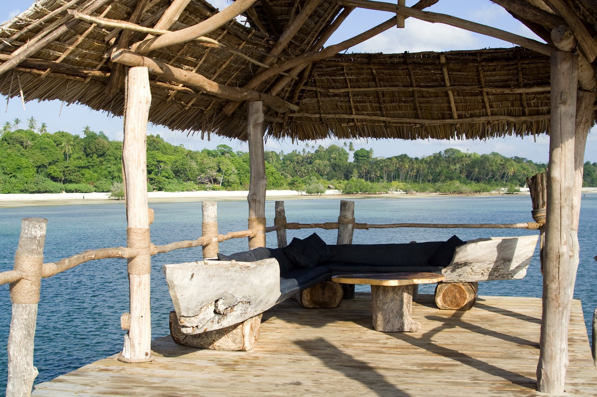 Couple relaxing by the infinity pool overlooking the ocean at Fundu Lagoon