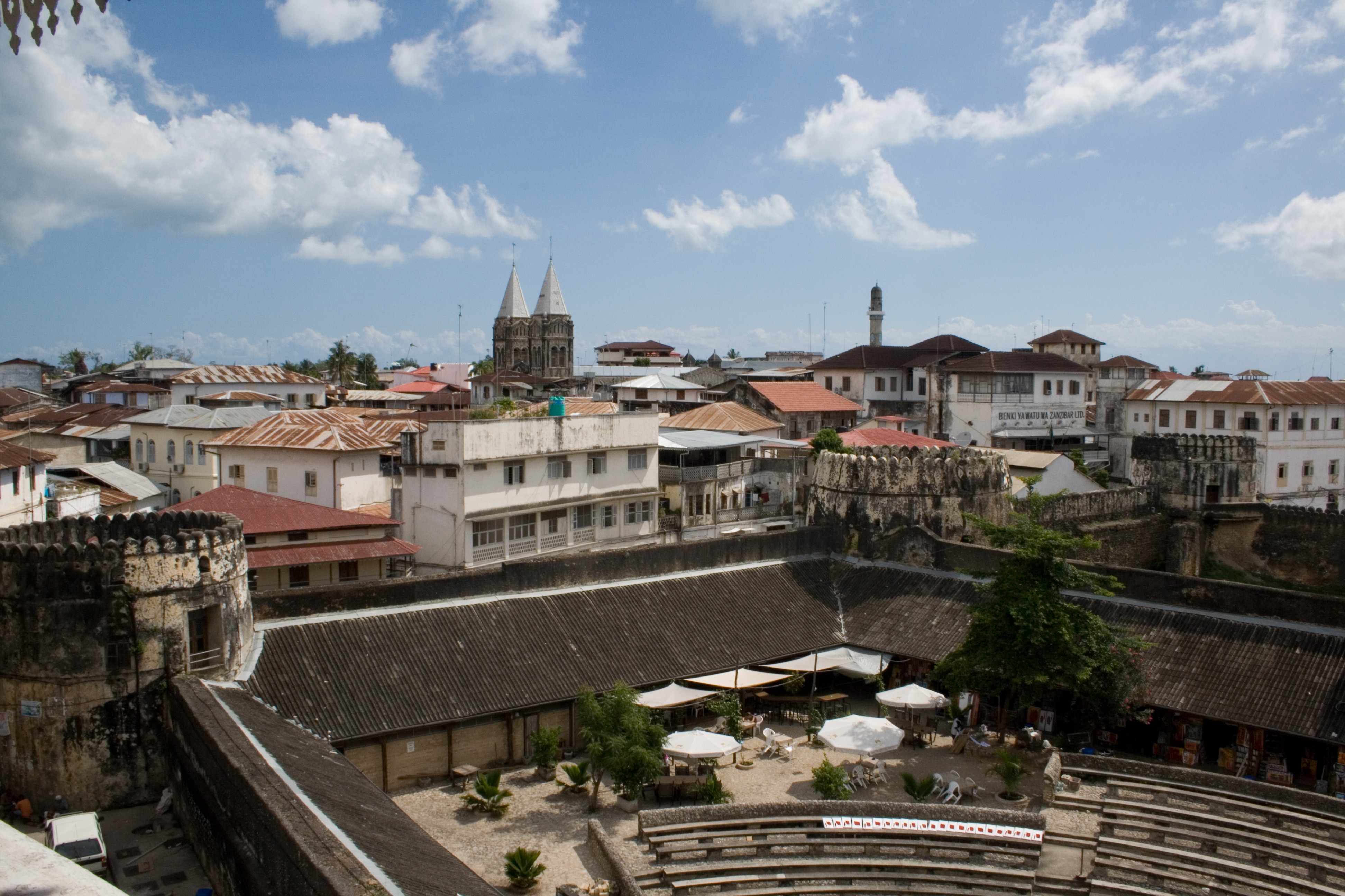 View over Stone Town's rooftops towards the Indian Ocean at sunset.