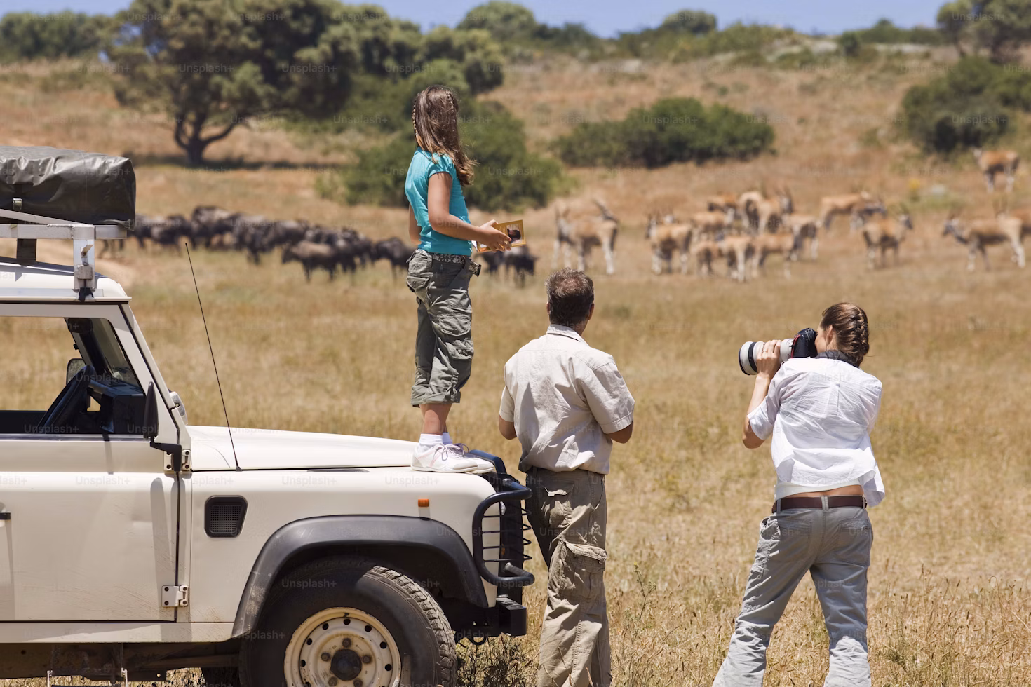 Photographer with a telephoto lens capturing wildlife on a Tanzanian safari.